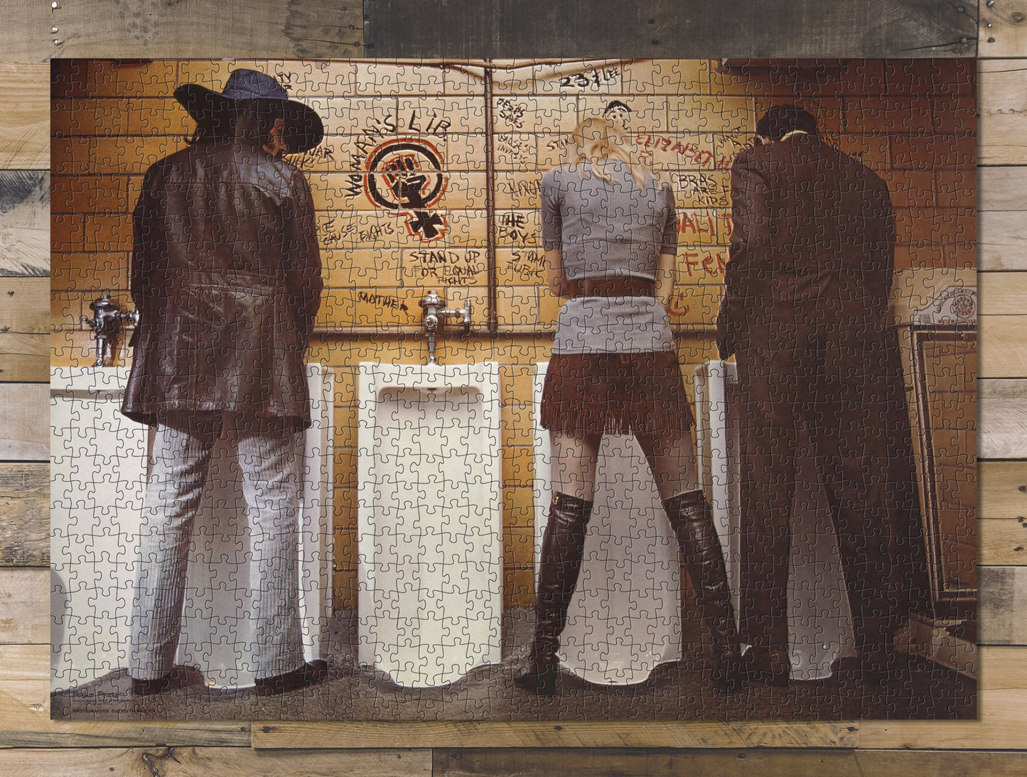 1000 piece puzzle Two men and a woman standing at urinals, with "woman's lib" graffiti on wall